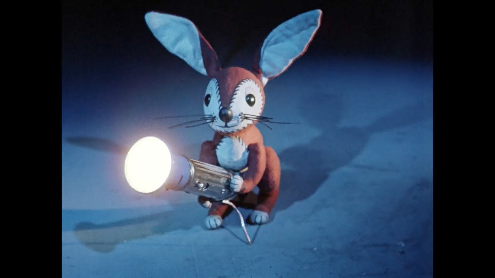 Der Hase haelt eine leuchtende Taschenlampe.